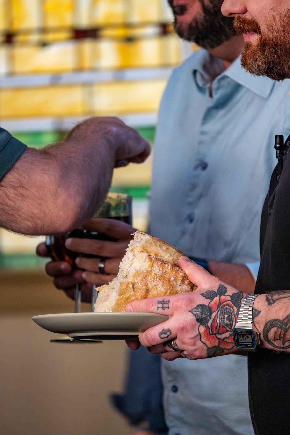 Bread being broken and served at the communion table.